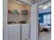 Convenient laundry room with washer, dryer, storage shelving, and easy bedroom access at 580 Shoreham Ne Ct, St Petersburg, FL 33716