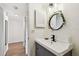 Bathroom with vanity and decorative mirror, with hall and wood floors in the background at 5817 Park N St # 310, St Petersburg, FL 33709