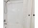 Shower with white tile surround, and a shower curtain with wooden button accents at 5817 Park N St # 310, St Petersburg, FL 33709