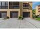 Exterior view of a building with garages, brown doors, and a concrete driveway at 5817 Park N St # 310, St Petersburg, FL 33709