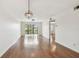 Bright living room with hardwood floors, modern light fixture, and sliding glass doors to a balcony at 5817 Park N St # 310, St Petersburg, FL 33709