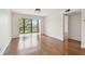Bright living room with hardwood floors, balcony access, and serene lake views at 5817 Park N St # 310, St Petersburg, FL 33709