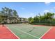 Full tennis court surrounded by trees, with a view of the condo building in the background at 5817 Park N St # 310, St Petersburg, FL 33709