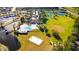 This aerial shot shows a community pool, volleyball court, soccer field, tennis courts, and a scenic pond at 5925 Sweet William Ter, Land O Lakes, FL 34639