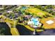 Aerial view showcasing community amenities including a pool, park, tennis courts, a soccer field and a scenic pond at 5925 Sweet William Ter, Land O Lakes, FL 34639