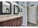 Bathroom with dual sinks, tile floors, dark wood cabinets, and a light blue wall at 5925 Sweet William Ter, Land O Lakes, FL 34639