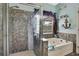 Bathroom featuring a shower with glass door, jacuzzi tub, and beach themed decor at 5925 Sweet William Ter, Land O Lakes, FL 34639