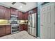 Well-equipped kitchen featuring stainless steel appliances, dark wood cabinetry, and tile flooring at 5925 Sweet William Ter, Land O Lakes, FL 34639