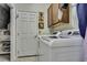 Laundry room with appliances, storage cabinets, and tile flooring at 5925 Sweet William Ter, Land O Lakes, FL 34639