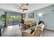 Cozy living room featuring a ceiling fan, comfortable seating, and access to a balcony with outdoor furniture at 5925 Sweet William Ter, Land O Lakes, FL 34639