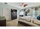 View of the main bedroom featuring TV, dresser, ceiling fan, and light blue painted walls at 5925 Sweet William Ter, Land O Lakes, FL 34639