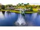 Beautiful lake view featuring a gazebo-covered dock with a fountain and overlooking a community pool area at 5925 Sweet William Ter, Land O Lakes, FL 34639