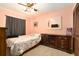 A bedroom with a dark wood dresser and bed with floral comforter at 5960 Boyette Rd, Wesley Chapel, FL 33545