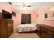 A bedroom with a television and two dressers with floral comforter at 5960 Boyette Rd, Wesley Chapel, FL 33545