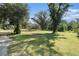 Lush front yard adorned with mature trees casting shadows on a well-maintained lawn in a country setting at 5960 Boyette Rd, Wesley Chapel, FL 33545