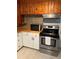 Cozy kitchen with wood cabinets, stainless steel stove, and modern appliances at 6345 Lambert Ln, New Port Richey, FL 34652
