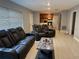 Spacious living room with reclining sofas, neutral tile flooring and easy access to the kitchen at 6345 Lambert Ln, New Port Richey, FL 34652