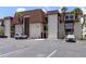 Exterior view of condo building with mature palms, convenient parking spaces, and neutral stucco facade at 6370 1St N St # 202, St Petersburg, FL 33702
