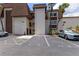 Exterior shot of the condominium featuring parking spaces, landscaping, and palm trees at 6370 1St N St # 202, St Petersburg, FL 33702