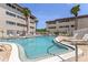 Inviting community pool surrounded by lounge chairs and white fencing, nestled between condo buildings at 6370 1St N St # 202, St Petersburg, FL 33702