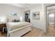 Bedroom featuring white wood bed, wood-look floors, and a peek into the ensuite bathroom at 6618 12Th N St, St Petersburg, FL 33702