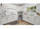 Bright kitchen featuring white cabinets, stainless steel appliances, and a window with a green outdoor view at 6618 12Th N St, St Petersburg, FL 33702