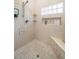 Shower with detailed tile work, including mosaic floor, built-in shelving, and a comfortable bench at 6618 12Th N St, St Petersburg, FL 33702
