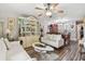 Open-concept layout showcases a living room with a decorative hutch, wood flooring, and a ceiling fan at 7523 Pitch Pine Cir # 184, Tampa, FL 33617