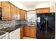 Updated kitchen with granite counters, a mosaic backsplash, and modern black appliances at 7625 Sun Island S Dr # 304, South Pasadena, FL 33707