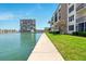 Beautiful waterfront view from the sidewalk, showcasing the lush lawn and complex building at 7625 Sun Island S Dr # 304, South Pasadena, FL 33707