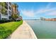 Scenic waterfront view from the grassy lawn and paved walkway, with a view of nearby condos at 7625 Sun Island S Dr # 304, South Pasadena, FL 33707