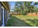 Large, grassy backyard with a wood fence, mature trees, and the side of a home at 816 9Th Sw Ave, Largo, FL 33770