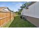 A clean backyard with a wood fence, green grass, and an installed air conditioner at 816 9Th Sw Ave, Largo, FL 33770