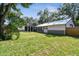 The backyard boasts a luscious lawn and a large structure with a garage door at 816 9Th Sw Ave, Largo, FL 33770