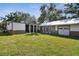 Expansive backyard with lush green grass and a detached garage/workshop with double doors at 816 9Th Sw Ave, Largo, FL 33770