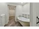 Bathroom with a clawfoot bathtub and wood-look tile floor, with hallway view at 816 9Th Sw Ave, Largo, FL 33770