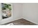 This bedroom has wood-look floors, a window providing an outside view, and white-painted walls at 816 9Th Sw Ave, Largo, FL 33770