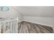 A finished bonus room features wood-look floors, fresh white paint, a small window, and stairs with white railings at 816 9Th Sw Ave, Largo, FL 33770