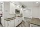 This kitchen offers white cabinetry, a farmhouse sink, and stainless steel microwave at 816 9Th Sw Ave, Largo, FL 33770