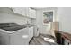 Functional laundry room with modern washer and dryer, white cabinetry, and a window at 816 9Th Sw Ave, Largo, FL 33770