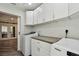 Laundry room featuring white cabinets and modern appliances, with a view into the living area at 816 9Th Sw Ave, Largo, FL 33770
