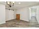 Open living room with laminate wood flooring, a sliding barn door, chandelier, and a view of the hallway at 816 9Th Sw Ave, Largo, FL 33770