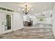 Open living room featuring gray wood-look flooring, recessed lights, and an adjacent kitchen at 816 9Th Sw Ave, Largo, FL 33770