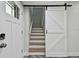 Staircase with new laminate flooring and a sliding barn door that adds to the home's overall aesthetic appeal at 816 9Th Sw Ave, Largo, FL 33770