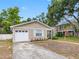 Inviting single-story home featuring an attached one-car garage and a well-maintained lawn at 8208 Volusia Pl, Tampa, FL 33637