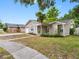 Charming single-story home features a front yard with lush greenery and an attached one-car garage at 8208 Volusia Pl, Tampa, FL 33637