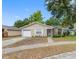 Lovely single-story home with a charming front yard, complemented by mature trees and a driveway at 8208 Volusia Pl, Tampa, FL 33637