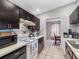 Efficient kitchen with black cabinets, white appliances, and a stylish tile backsplash at 8208 Volusia Pl, Tampa, FL 33637