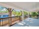 Spacious balcony with wooden railings, white supports and lush landscaping views at 8521 N 29Th St, Tampa, FL 33604