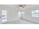Bright bedroom features a ceiling fan, carpeted floor, and a door with glass panels at 8521 N 29Th St, Tampa, FL 33604